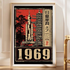 以下が含まれることがあります： 赤い背景に発射台上のロケットの緻密なイラストが描かれた縦型ポスター。黒い木のシルエット、高いガントリー構造、日本語のテキスト、そして下部には大きく太字で1969という数字がデザインされています。