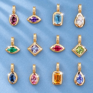 Könnte beinhalten: Eine Sammlung von zwölf goldfarbenen Metallanhängern, die jeweils einen facettierten Edelstein in verschiedenen Formen wie oval, marquise, rechteckig und tropfenförmig aufweisen, mit einer kleinen vertikalen Öse an der Oberseite jedes Stücks.