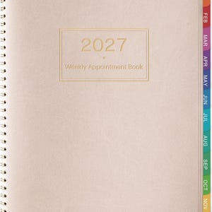 May include: A light beige 2027 weekly appointment book with a spiral binding on the left side. The cover features the text 2027 Weekly Appointment Book in gold lettering. The right edge has colorful monthly tabs labeled JAN through DEC.