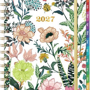 May include: A 2027 spiral-bound planner featuring a white cover with a colorful botanical print of various flowers, green leaves, and a yellow ladybug. The planner includes a gold elastic closure and monthly tab dividers along the right edge.