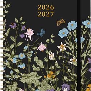 May include: A black spiral-bound planner with the text 2026 2027 printed in gold. The cover features a botanical illustration of various wildflowers in shades of blue, purple, pink, and orange, along with two small butterflies on a black background.