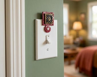 Künstlerisch gefertigter, einzigartiger Lichtschalteraufsatz im gotischen Goldstern-Design, karmesinrote Wandplatten-Medaillon-Akzent