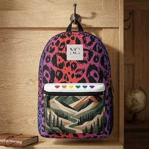 May include: A backpack featuring a vibrant pink, purple, and black leopard print pattern. It includes a white rectangular patch with the text NC, a white front pocket strip with six small colored hearts, and a mountain landscape graphic below.
