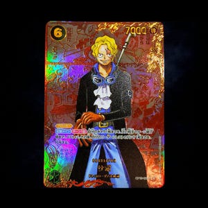 May include: A holographic trading card featuring a blonde character with goggles, wearing a black coat and blue pants, holding brown gloves. The card displays the number 6, the value 7000, and Japanese text, with a metallic gold and red finish.