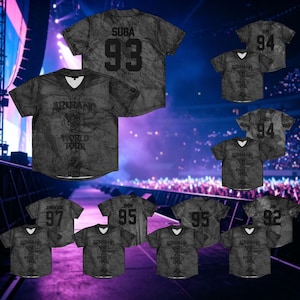 Peut inclure: Un maillot à manches courtes boutonné gris foncé avec un motif marbré, un col en V et le texte "ARIRANG WORLD TOUR" imprimé sur le devant. Le dos affiche le nom "SUGA" au-dessus du numéro "93" en lettres noires audacieuses.