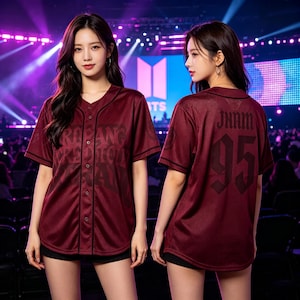 Pode incluir: Uma camisa de beisebol bordô com botões e acabamento preto, apresentando o texto JHAM e o número 95 nas costas em uma fonte gótica escura. A frente exibe uma estampa gráfica grande e sutil. A camisa é feita de tecido de malha texturizado.
