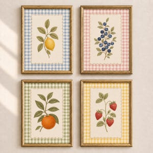 Puede incluir: Un conjunto de cuatro cuadros de pared con ilustraciones botánicas de un limón, arándanos, una naranja y fresas. Cada lámina está centrada sobre un fondo crema con un borde festoneado y un marco con estampado de cuadros vichy.