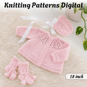 Peut inclure: Un cardigan pour bébé en tricot rose clair, un bonnet assorti avec un ruban en satin blanc et deux chaussons à pompons. L'ensemble présente des détails en dentelle sur l'empiècement et les poignets. Texte : Knitting Patterns Digital 18 inch.