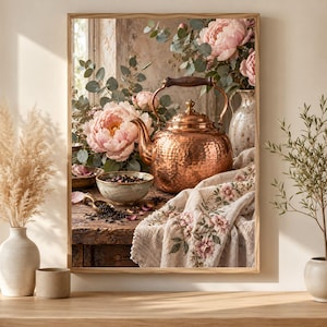 Puede incluir: Una impresión artística enmarcada que muestra una tetera de cobre martillado sobre una mesa de madera rústica, acompañada de un cuenco con hojas de té, una pequeña cuchara de metal, un paño bordado floral y un jarrón con peonías rosas.