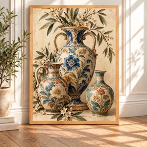 May include: A framed wall art print featuring three ornate ceramic vases in varying sizes. The vases are decorated with intricate blue, gold, and cream floral patterns and foliage. White blossoms and green leaves are arranged around the vessels.
