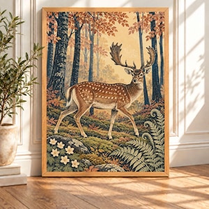 May include: A framed wall art print featuring an autumn forest scene with a spotted fallow deer standing in the centre. The deer has large antlers and is surrounded by mossy ground, ferns, white flowers, and tall trees with orange autumn leaves.