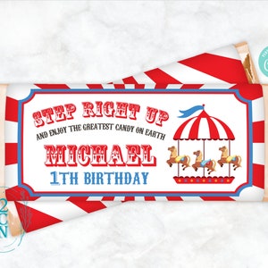 May include: A red and white striped background with a blue and white circus tent and carousel horses. The text "STEP RIGHT UP AND ENJOY THE GREATEST CANDY ON EARTH MICHAEL 1TH BIRTHDAY" is printed on the front of the candy bar wrapper.