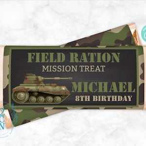May include: A green, brown, and black camouflage patterned chocolate bar wrapper with a cartoon tank and the text "Field Ration Mission Treat Michael 8th Birthday".