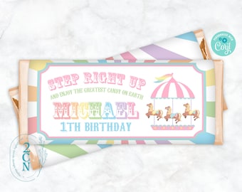 May include: A pastel pink and blue candy bar wrapper with a colorful carousel design. The text reads "Step Right Up and Enjoy the Greatest Candy on Earth Michael 1st Birthday".
