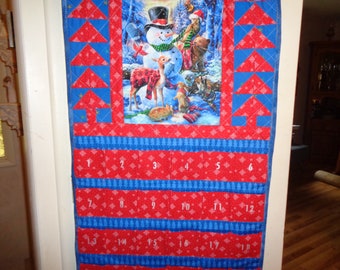 Quilted Advent Calendar featuring forest animals building a snowman and Christmas trees.