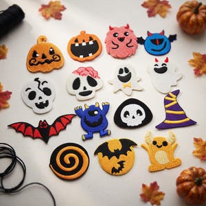 May include: A collection of embroidered Halloween-themed patches featuring various designs including pumpkins, skulls, ghosts, a bat, a witch hat, and colorful monsters. The patches are arranged in a grid pattern with orange, black, white, blue, and red colors.