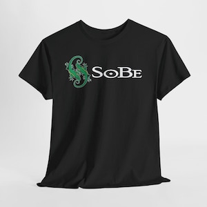May include: A black short-sleeve t-shirt featuring a graphic of two intertwined green lizards on the left chest area. Next to the lizards, the word SOBE is printed in white capital letters with a diamond shape inside the letter O.
