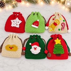Può includere: Sei piccole borse a sacchetto in uncinetto con motivi natalizi. Le borse sono rosse, verdi e beige, decorate con applicazioni che includono un fiocco di neve bianco, un cappello di Babbo Natale, un omino di pan di zenzero, un bastoncino di zucchero, una renna, Babbo Natale e un albero.