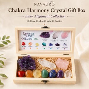May include: A light-colored wooden box containing ten crystals nestled in shredded paper. The lid interior features a printed guide labeled Chakra Travel Collection, displaying images and names of amethyst, clear quartz, rose quartz, red jasper, carnelian, citrine, aventurine, lapis lazuli, and clear quartz.