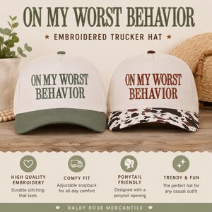 May include: Two trucker hats with the text ON MY WORST BEHAVIOR embroidered on the front. The left hat has a cream crown and olive green brim. The right hat has a cream crown and a brown and white cow print brim with brown embroidery.