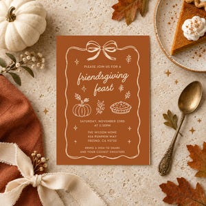 May include: A rectangular invitation card with a burnt orange background and white line art featuring a bow, pumpkin, and pie. The text reads: PLEASE JOIN US FOR A friendsgiving feast, SATURDAY, NOVEMBER 23RD AT 5:30PM, THE WILSON HOME, 456 PUMPKIN WAY, FRESNO, CA 93720, BRING A DISH TO SHARE AND YOUR COZIEST SWEATERS.