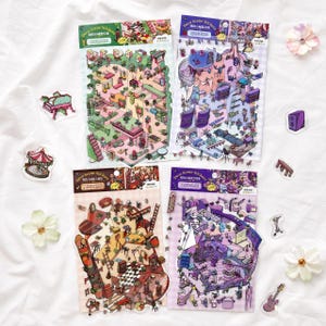 May include: Four sheets of Deco Scene Stickers featuring intricate isometric room illustrations in green, purple, brown, and violet colour palettes. Each sheet includes various furniture, decor, and small character elements with text labels.