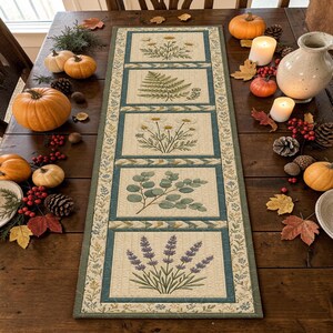 May include: A rectangular fabric table runner featuring five distinct panels with botanical illustrations of daisies, a fern, more daisies, eucalyptus leaves, and lavender, all framed by a teal and cream border with floral accents.