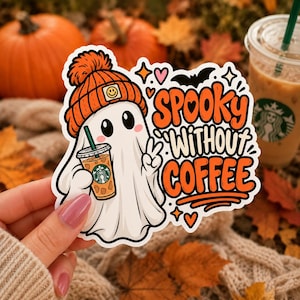 Könnte beinhalten: Ein gestanzter Aufkleber mit einem weißen Geist, der eine orangefarbene Mütze mit Smiley-Aufnäher trägt und einen Eiskaffee mit grünem Strohhalm hält. Der Text lautet SPOOKY WITHOUT COFFEE in Orange und Schwarz, verziert mit Fledermaus, Herzen und Sternen.