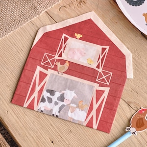 Può includere: Un tovagliolo di carta a forma di fienile rosso con un'illustrazione stampata di animali da fattoria. Il design include una mucca bianca e nera, una pecora bianca, una gallina marrone, un maiale rosa e pulcini gialli nel fienile.
