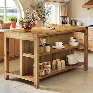 May include: A rectangular wooden kitchen island with a natural grain finish, featuring an open shelving unit on one side. The shelves hold various kitchen items including glass jars, ceramic mugs, stacked bowls, paper bags, and a white toaster.