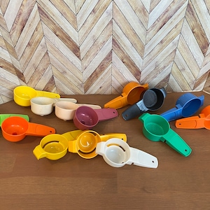 May include: A collection of 11 plastic funnels in various colors, including green, orange, yellow, red, and blue. Some funnels have a strainer or a small spout.