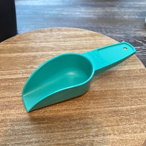 May include: A teal plastic scoop with a handle. The scoop has the word "ORIGINAL" printed on the side.