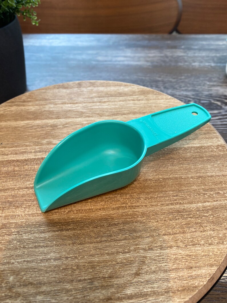 May include: A teal plastic scoop with a handle. The scoop has the word "ORIGINAL" printed on the side.