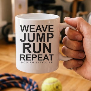 Könnte beinhalten: Ein weißer Keramikbecher mit schwarzem Text, der WEAVE JUMP RUN REPEAT und DOG AGILITY LIFE lautet. Der Becher hat einen glatten zylindrischen Körper und einen geschwungenen Henkel an der Seite, konzipiert für Heißgetränke mit Hundesport-Motiv.