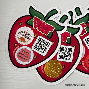 May include: A strawberry-shaped sticker featuring a green stem, the text THANK YOU!, a Smith's Bakery logo, a QR code, and a circular label with the text 5% off your next purchase. A gold glitter circle is also visible on the sticker surface.
