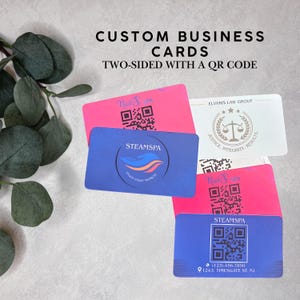 May include: A collection of rectangular business cards featuring various designs, including bright pink cards with black QR codes, a blue card with the SteamSpa logo, and a white card with the Elvaris Law Group logo and scales of justice icon.