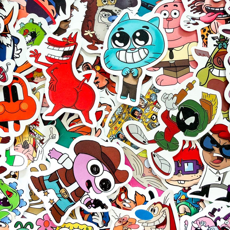May include: A collection of assorted vinyl stickers featuring various colorful cartoon characters, including a blue cat, a red devil-like figure, a green alien in a helmet, and a purple character wearing a brown cowboy hat and holding a gun.
