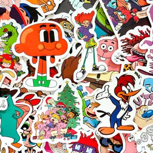 May include: A collection of assorted vinyl stickers featuring various cartoon characters, including a bright orange fish, a red-headed person in a purple shirt, and a woodpecker, alongside a festive scene with characters gathered around a tree.