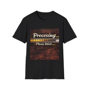 May include: A black short-sleeved t-shirt featuring a central graphic with a dark, textured brown background. The design includes the white text "Processing..." above a horizontal loading bar and the white text "Please Wait..." below it.
