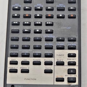 May include: A black Sony RM-P313 programmable remote control featuring numerous rectangular buttons for audio, video, and television functions. The device includes a silver-toned section for input selection and volume control, with white text labels throughout.