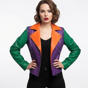 May include: A color-blocked motorcycle jacket featuring vibrant green sleeves, a purple bodice, and bright orange lapels. The jacket includes a silver-toned metal zipper closure, notched lapels, and long sleeves, constructed with a smooth finish.
