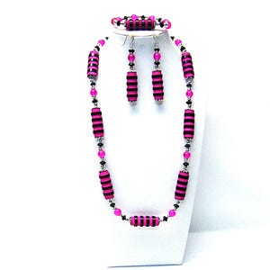 Collana/braccialetto/orecchini lunghi in resina fucsia con anello nero e perline di vetro craquelé fucsia