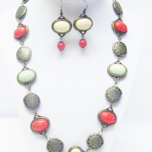 Cabujón de resina ovalada multicolor en collar / arete de base de bronce antiguo