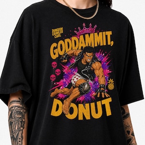 Peut inclure: Un t-shirt noir avec une illustration graphique d'un personnage musclé en gilet de cuir et caleçon à cœurs. Le texte "DUNGEON CRAWLER CARL" et "GODDAMMIT, DONUT" est écrit en jaune, avec une couronne, des crânes et une icône d'ananas.