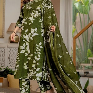 Pu&ograve; includere: Un completo a tre pezzi color verde oliva composto da una tunica a maniche lunghe, pantaloni abbinati e una sciarpa trasparente. Il set presenta un motivo a foglie bianche e ricami decorativi lungo lo scollo e i polsini delle maniche.