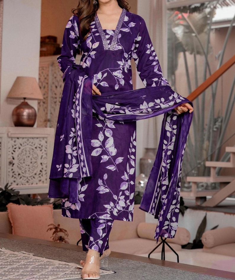 Pu&ograve; includere: Un completo composto da tunica a maniche lunghe e pantaloni color viola scuro con un motivo a foglie bianche. La tunica presenta uno scollo a V decorato con un bordo metallico argentato. Una sciarpa coordinata con stampa a foglie &egrave; inclusa.