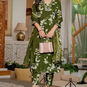 Pu&ograve; includere: Un completo a tre pezzi color verde oliva composto da una tunica a maniche lunghe con scollo a V, pantaloni abbinati e una sciarpa coordinata, il tutto decorato con un motivo a foglie bianche. Lo scollo della tunica presenta decorazioni argentate.