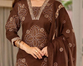 May include: A dark brown long-sleeved tunic featuring a V-neckline with metallic trim and a repeating cream-colored circular dot pattern. The garment includes a matching brown shawl draped over the shoulder, adorned with the same circular motif.
