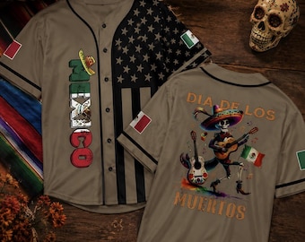 May include: A tan baseball jersey featuring a vertical MEXICO graphic with a sombrero on the front, a black and white American flag pattern on one side, and a Dia de los Muertos skeleton playing a guitar on the back with the text DIA DE LOS MUERTOS.