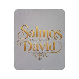 Puede incluir: Una manta rectangular de color gris claro con el texto dorado Salmos de David en una fuente serif decorativa. El diseño incluye elegantes adornos y un pequeño gráfico ornamental centrado debajo del texto sobre la suave superficie.